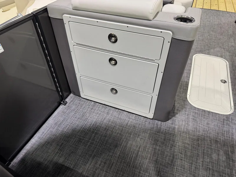Slide: The Image of Interior of 2025 Godfrey AquaPatio 255 ULC boat with storage drawers and carpeted flooring. - 9