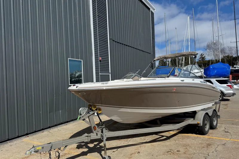 Slide: The Image of 2004 Four Winns 210 Horizon boat on trailer near a large building. - 1