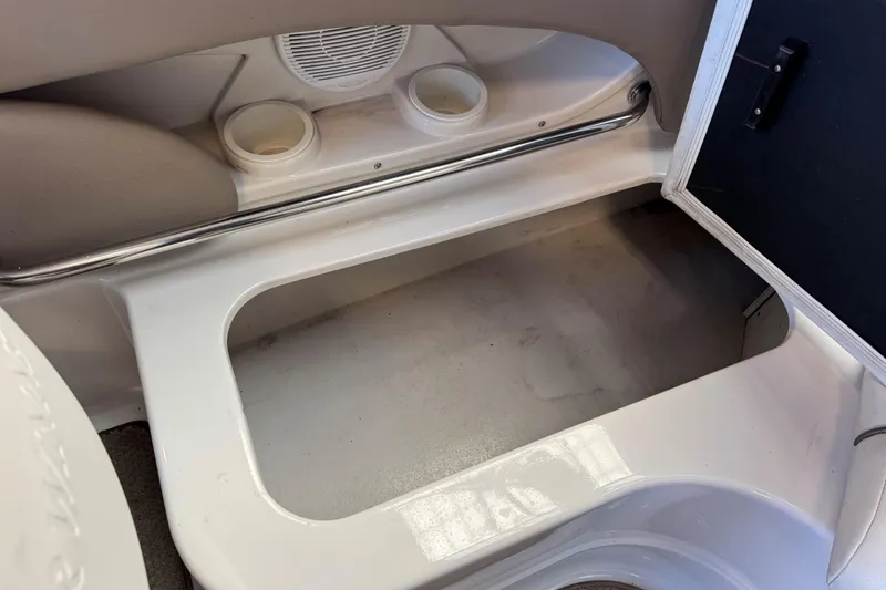 Slide: The Image of 2004 Four Winns 210 Horizon boat interior storage compartment with cup holders and speaker. - 15
