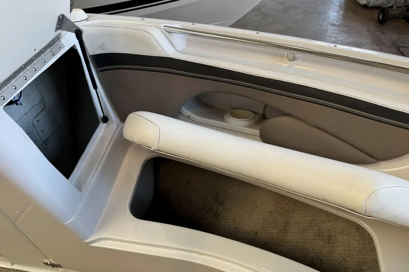 Slide: The Image of Interior view of a 2004 Four Winns 210 Horizon boat, featuring white seating and storage area. - 17