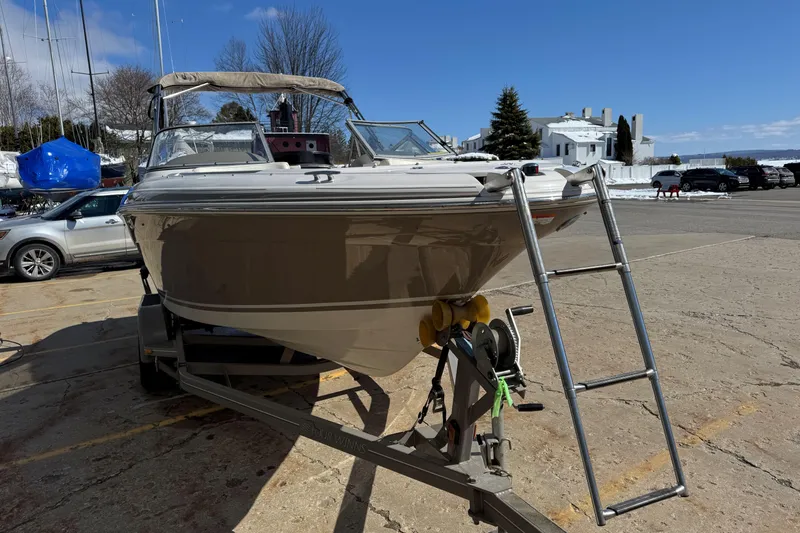 Slide: The Image of 2004 Four Winns 210 Horizon boat on trailer with ladder, parked outdoors. - 4