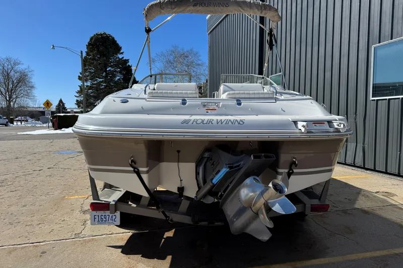 Slide: The Image of 2004 Four Winns 210 Horizon boat, rear view, parked outdoors on a sunny day. - 5