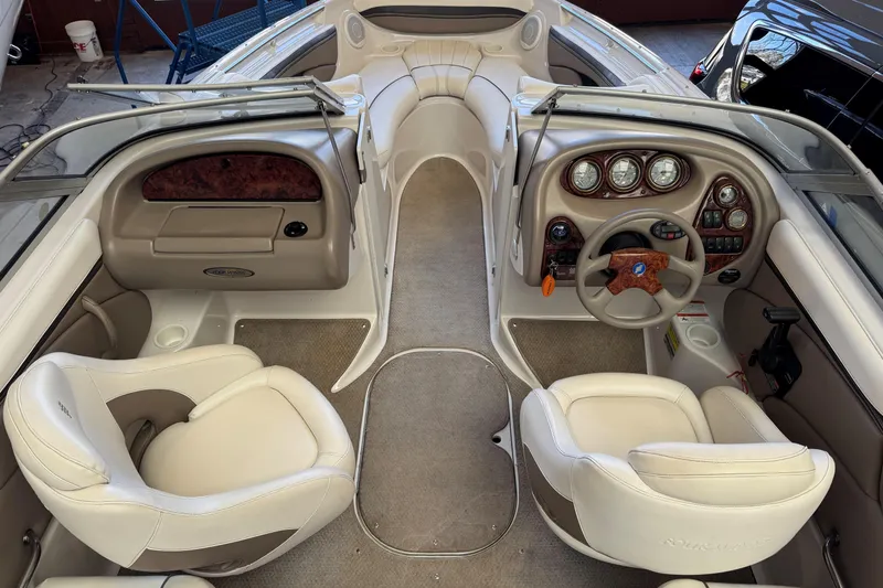 Slide: The Image of 2004 Four Winns 210 Horizon boat interior with beige seating and dashboard controls. - 9