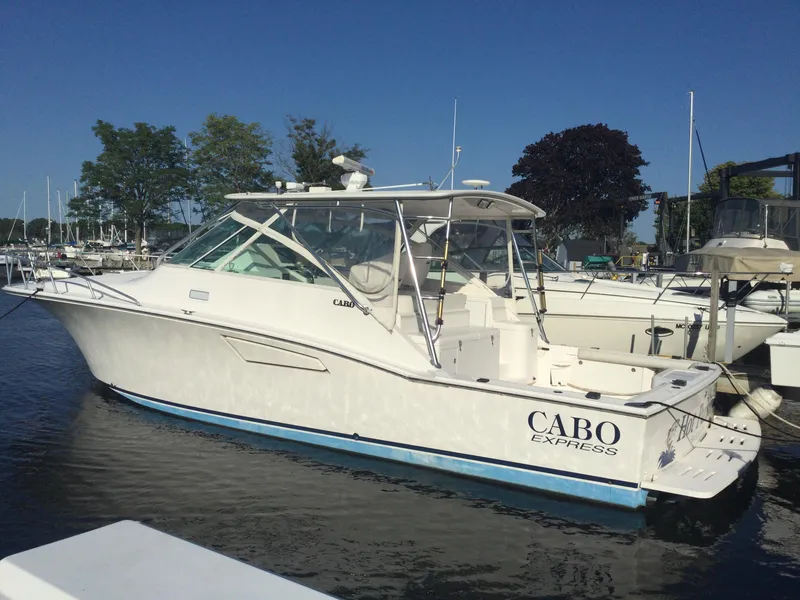 Slide: The Image of 2006 Cabo 40 Express boat docked in a marina under clear blue skies. - 0