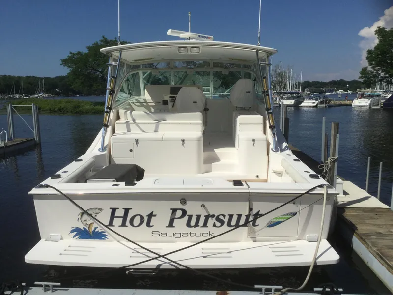 Slide: The Image of 2006 Cabo 40 Express boat named "Hot Pursuit" docked at a marina. - 1