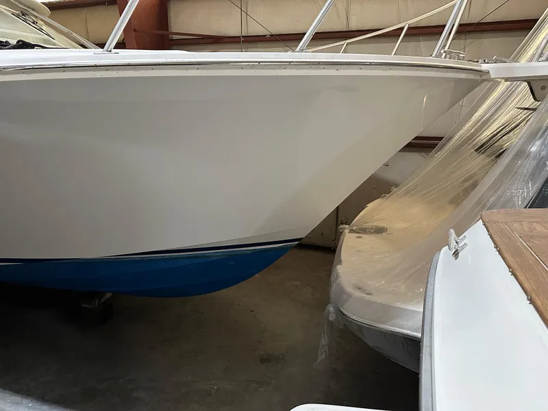 Slide: The Image of 2006 Cabo 40 Express boat in storage, featuring sleek white hull and blue bottom. - 24