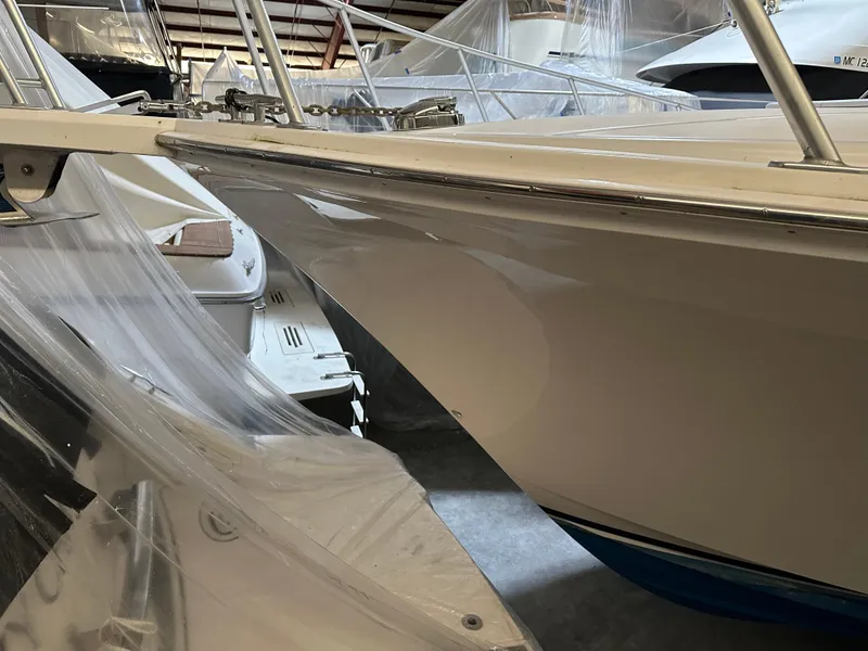 Slide: The Image of 2006 Cabo 40 Express boat in storage, partially covered, with visible bow and railings. - 25