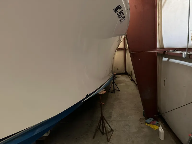 Slide: The Image of 2006 Cabo 40 Express boat in storage, supported by stands in a garage. - 26
