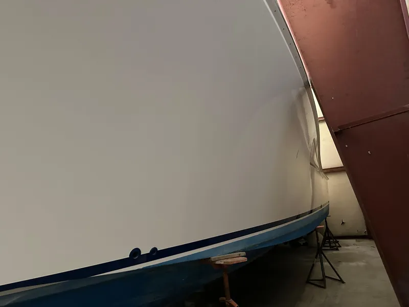 Slide: The Image of 2006 Cabo 40 Express boat in storage, side view with blue hull. - 27