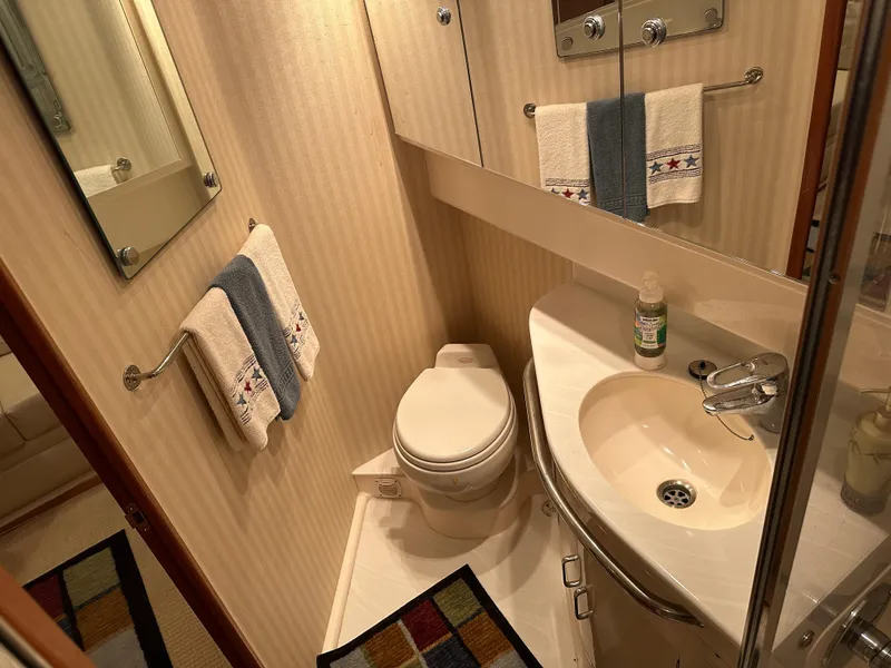 Slide: The Image of Compact bathroom in a 2006 Cabo 40 Express yacht, featuring a toilet and sink. - 33