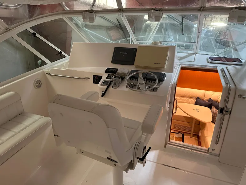 Slide: The Image of 2006 Cabo 40 Express yacht helm with modern controls and cozy cabin interior. - 5