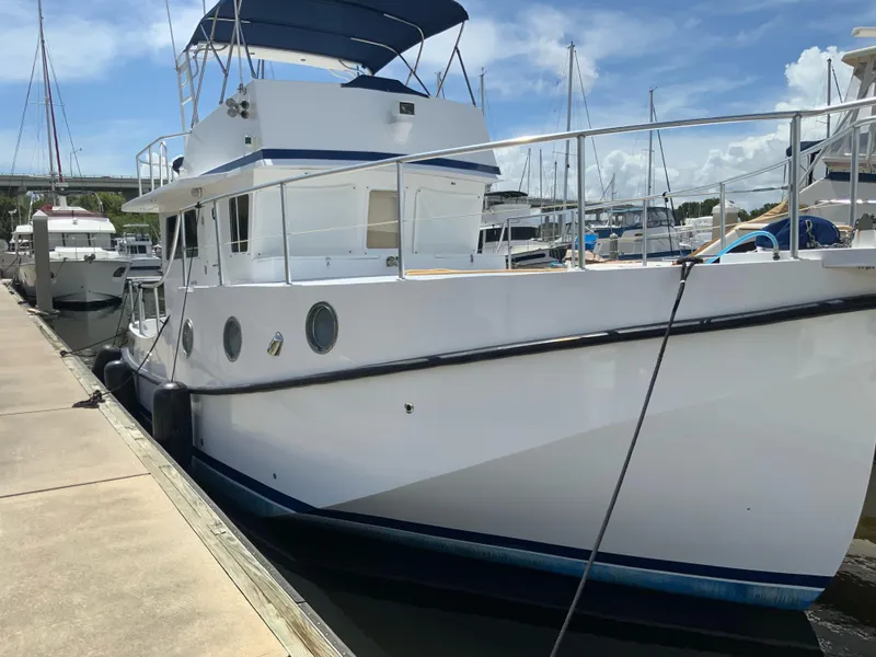 Slide: The Image of 2008 Great Harbour N37 yacht docked at marina, featuring white hull and blue canopy. - 10