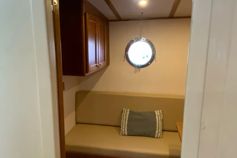 Slide: The Image of Cozy interior of 2008 Great Harbour N37 boat with porthole and cushioned seating. - 15