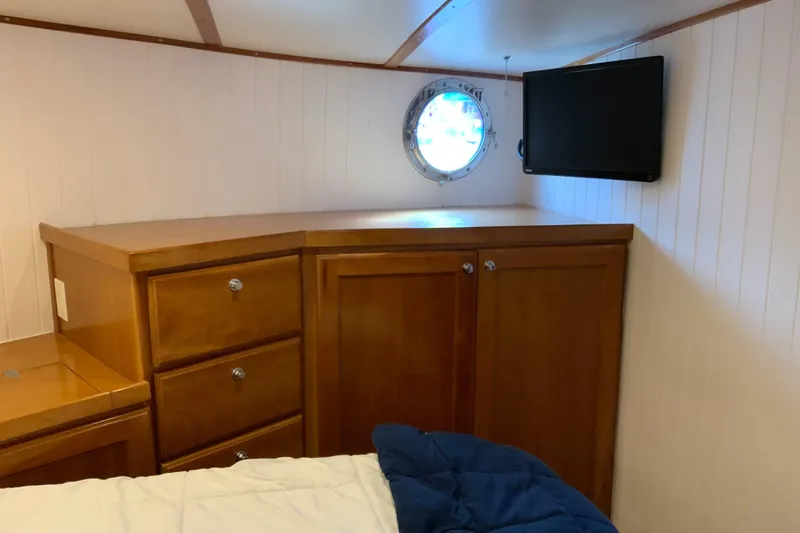 Slide: The Image of 2008 Great Harbour N37 cabin interior with wooden cabinets, porthole, and wall-mounted TV. - 18