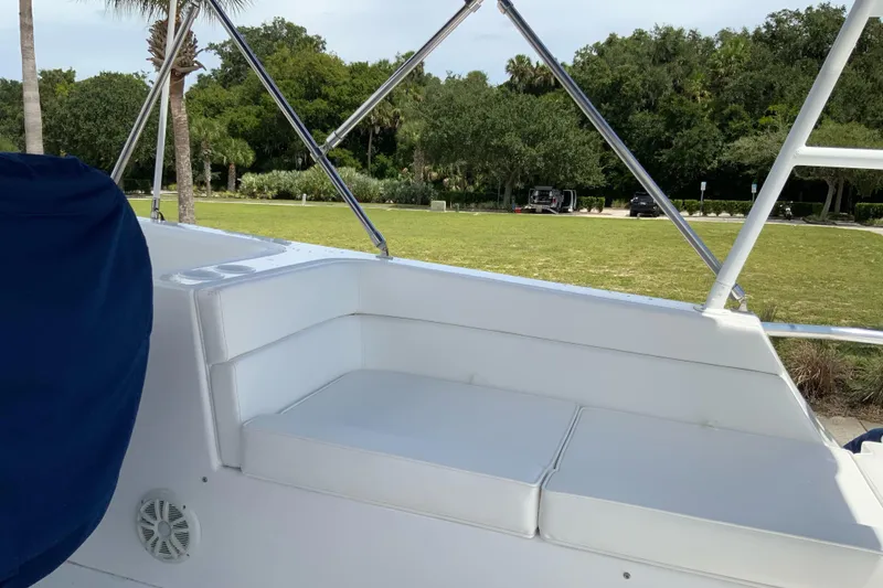 Slide: The Image of 2008 Great Harbour N37 boat with white seating and blue cover, docked near a grassy area. - 29