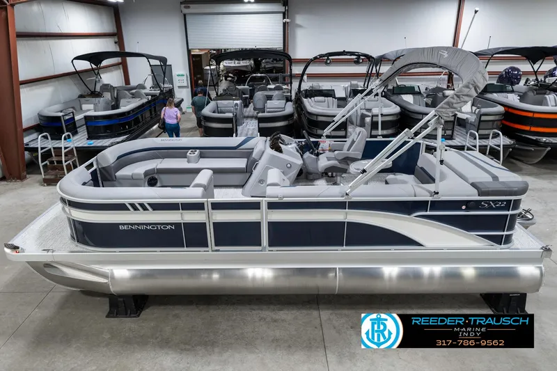 Slide: The Image of 2025 Bennington 22 SXL pontoon boat in showroom, side view. - 1