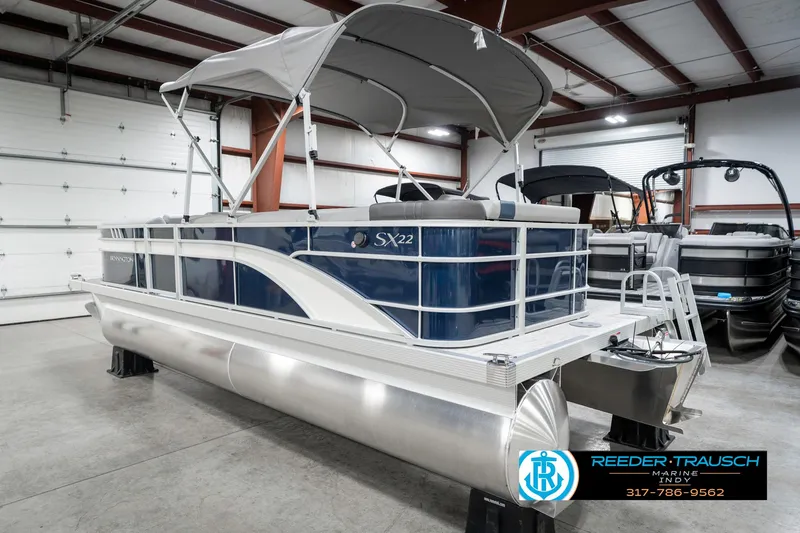 Slide: The Image of 2025 Bennington 22 SXL pontoon boat in showroom with canopy and sleek design. - 10