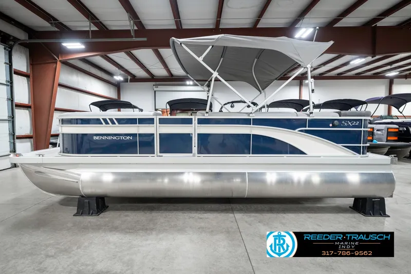 Slide: The Image of 2025 Bennington 22 SXL pontoon boat in a showroom with canopy. - 11