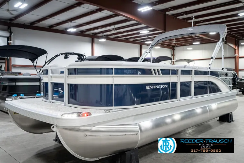 Slide: The Image of 2025 Bennington 22 SXL pontoon boat in showroom, featuring sleek design and modern amenities. - 2