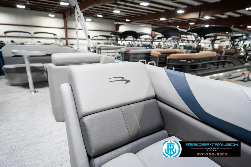 Slide: The Image of 2025 Bennington 22 SXL pontoon boat interior with gray seating in showroom. - 24