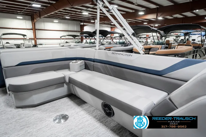 Slide: The Image of 2025 Bennington 22 SXL pontoon boat interior with gray seating in a showroom. - 27