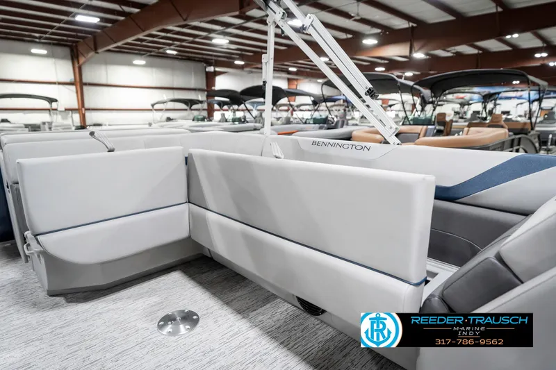 Slide: The Image of 2025 Bennington 22 SXL pontoon boat interior with white seating in a showroom. - 28