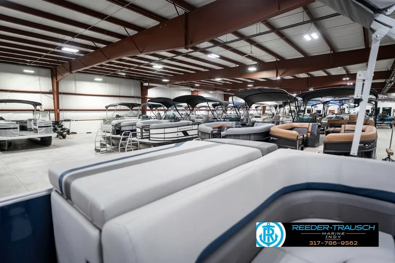 Slide: The Image of Indoor showroom displaying 2025 Bennington 22 SXL boats with various seating arrangements. - 30