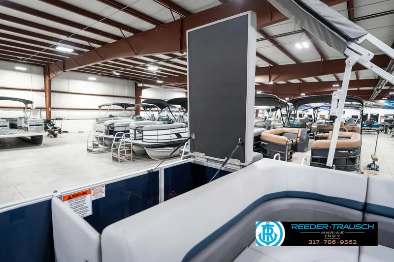 Slide: The Image of 2025 Bennington 22 SXL pontoon boats displayed in a spacious indoor showroom. - 31