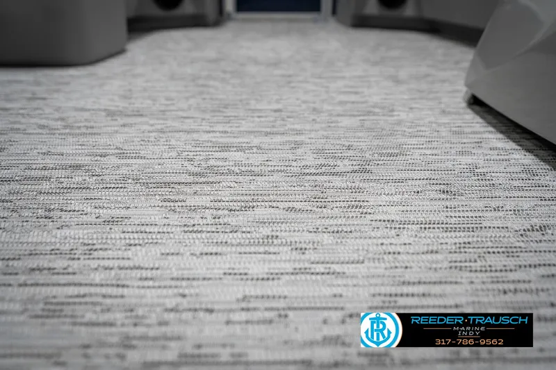 Slide: The Image of 2025 Bennington 22 SXL boat interior with textured flooring, Reeder-Trausch logo visible. - 47