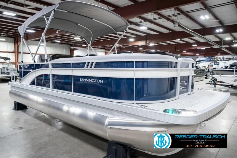 Slide: The Image of 2025 Bennington 22 SXL pontoon boat in showroom with canopy and sleek design. - 6