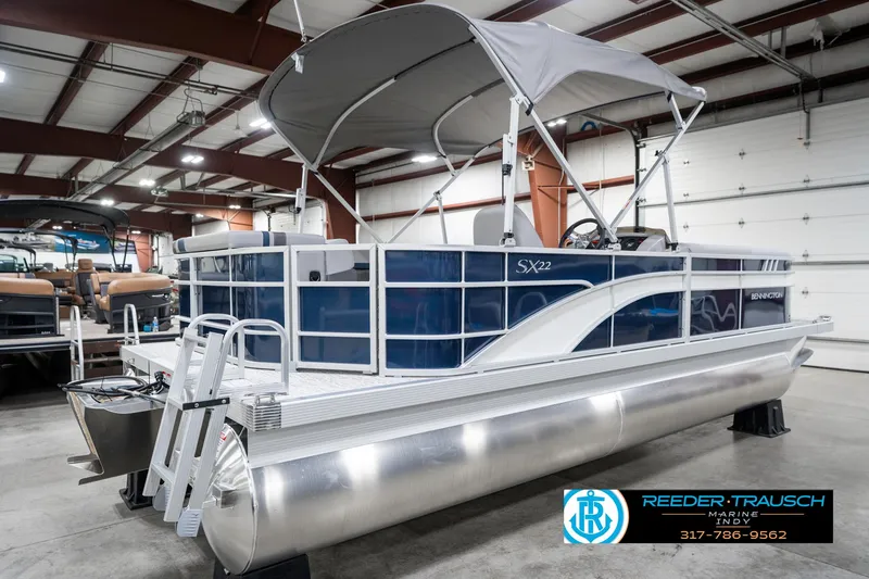 Slide: The Image of 2025 Bennington 22 SXL pontoon boat in showroom with canopy and sleek design. - 8