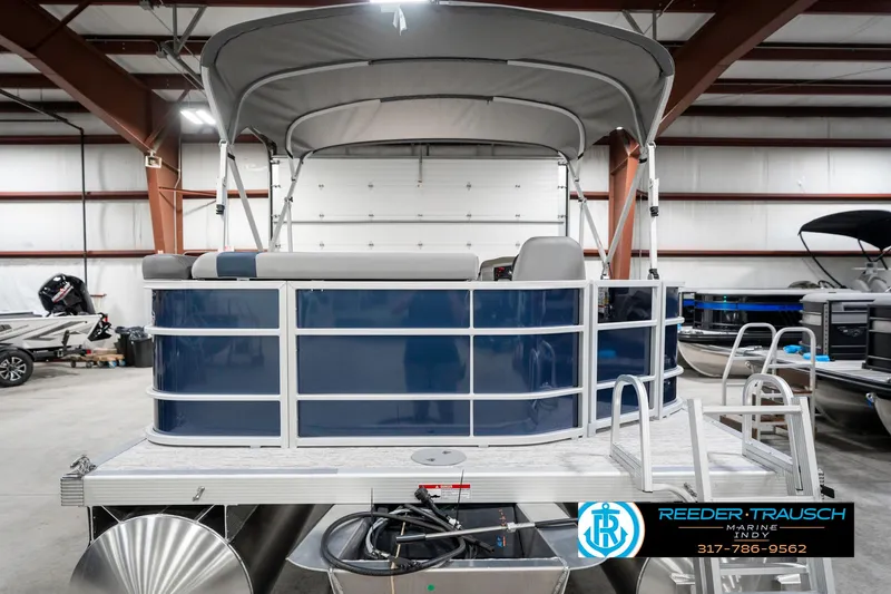Slide: The Image of 2025 Bennington 22 SXL pontoon boat in showroom, featuring blue and white design. - 9