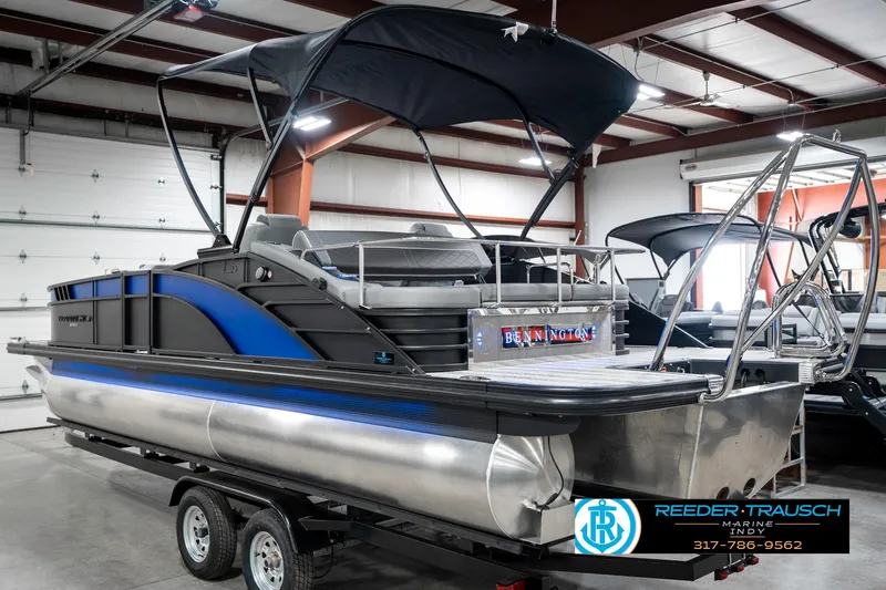 Slide: The Image of 2025 Bennington 23 LTSB pontoon boat with canopy in a showroom on a trailer. - 10