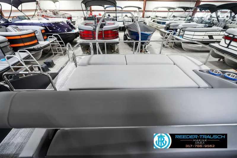 Slide: The Image of 2025 Bennington 23 LTSB pontoon boat in showroom, featuring spacious seating and modern design. - 18