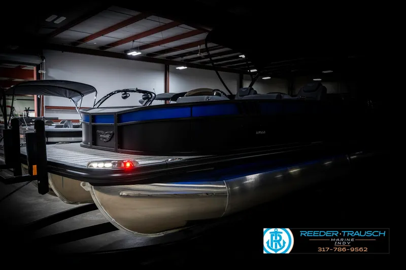 Slide: The Image of 2025 Bennington 23 LTSB pontoon boat in a dimly lit showroom. - 4