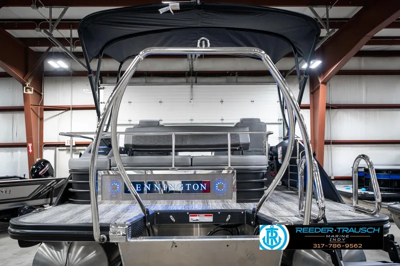 Slide: The Image of 2025 Bennington 23 LTSB pontoon boat in showroom, rear view with canopy and logo. - 9