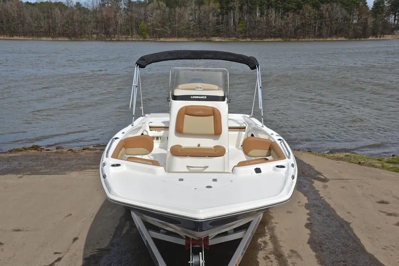 Slide: The Image of 2023 NauticStar 211 Hybrid boat docked by a serene lake. - 17