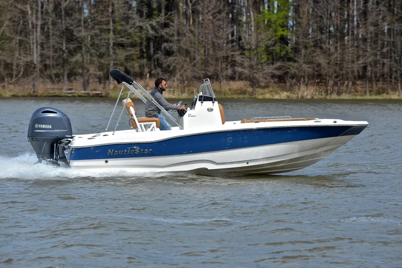 Slide: The Image of 2023 NauticStar 211 Hybrid boat cruising on a lake with a Yamaha engine. - 3