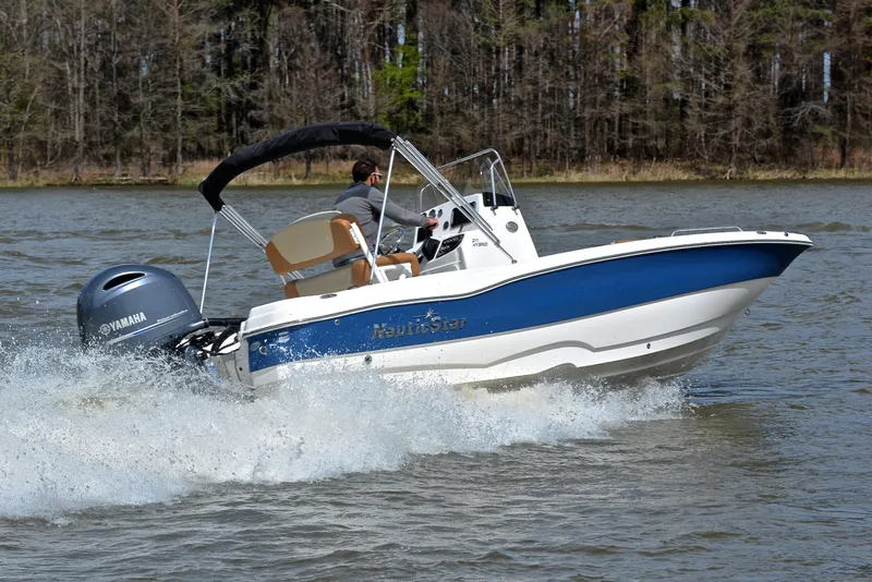 Slide: The Image of 2023 NauticStar 211 Hybrid boat cruising on a lake with Yamaha engine. - 5