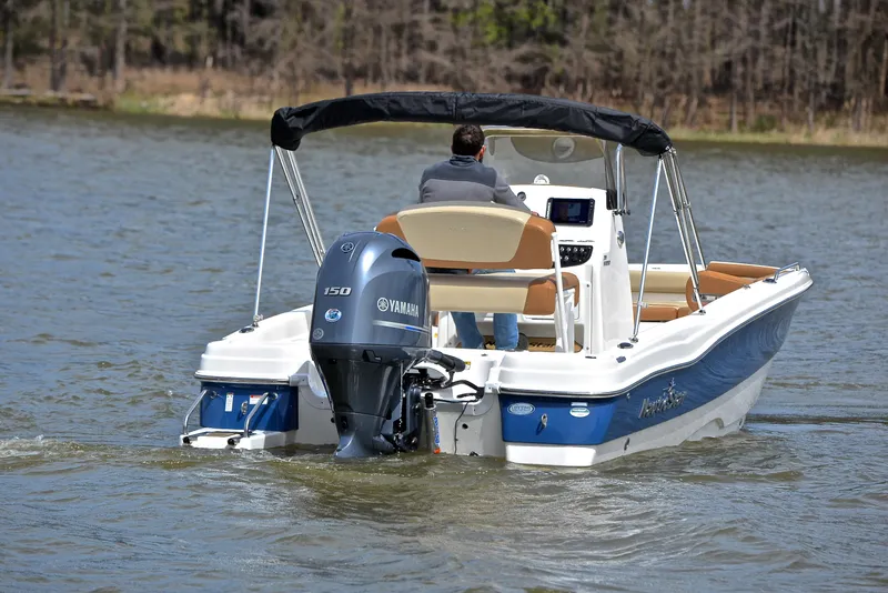 Slide: The Image of 2023 NauticStar 211 Hybrid boat cruising on a lake with Yamaha outboard motor. - 8