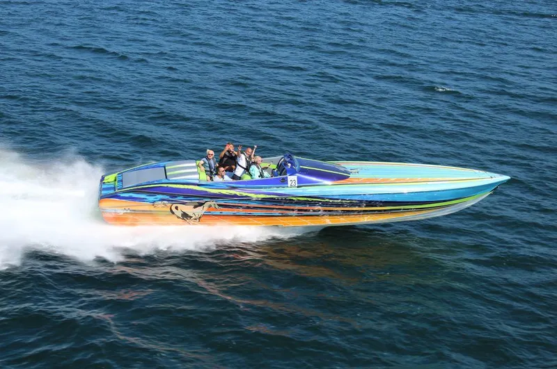 Slide: The Image of 2008 Outerlimits 39 Quattro speedboat racing on open water, vibrant design, multiple passengers. - 12