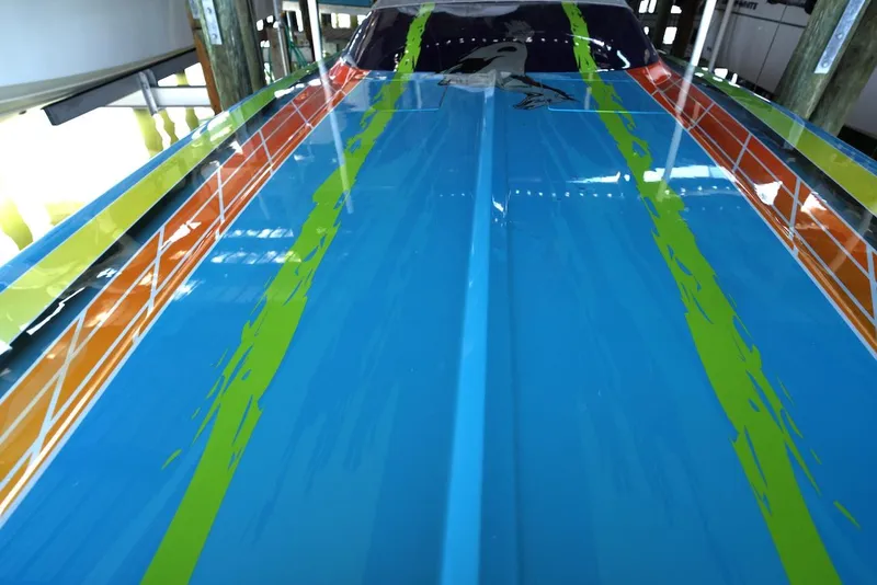 Slide: The Image of 2008 Outerlimits 39 Quattro boat with vibrant blue, orange, and green paint design. - 16