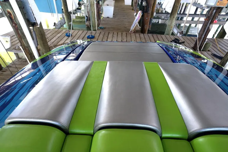 Slide: The Image of 2008 Outerlimits 39 Quattro boat with vibrant green and silver seating on a wooden dock. - 17