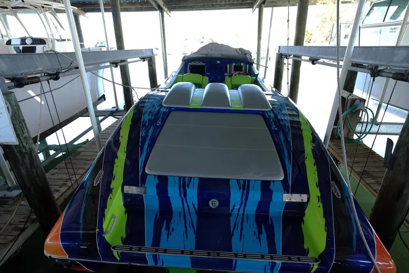 Slide: The Image of 2008 Outerlimits 39 Quattro speedboat with vibrant blue and green design in dock. - 18