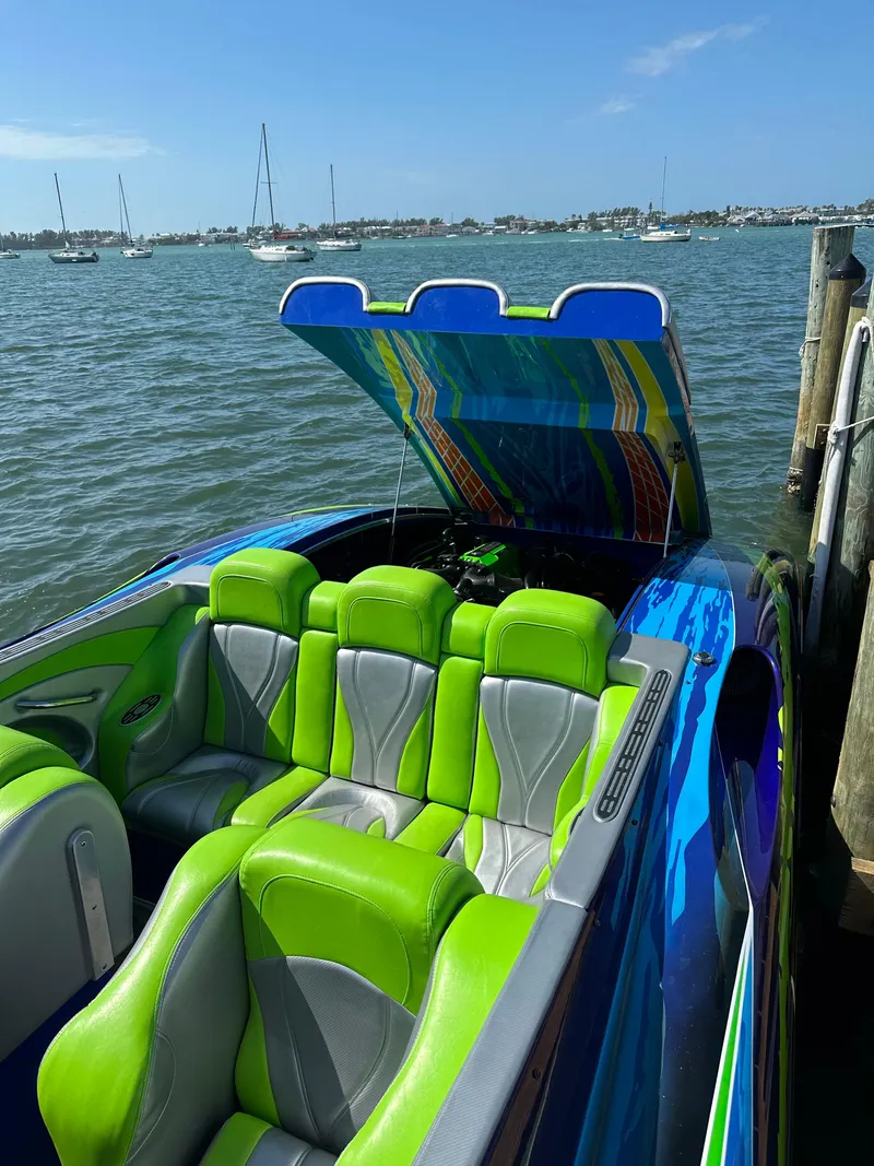 Slide: The Image of 2008 Outerlimits 39 Quattro speedboat with vibrant green and blue seating docked by the water. - 21
