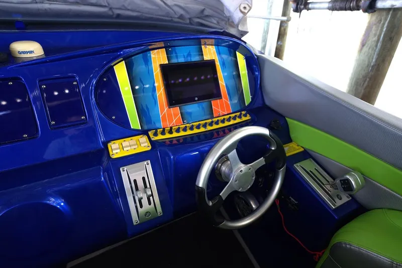 Slide: The Image of 2008 Outerlimits 39 Quattro cockpit with vibrant blue and green dashboard, steering wheel, and controls. - 25