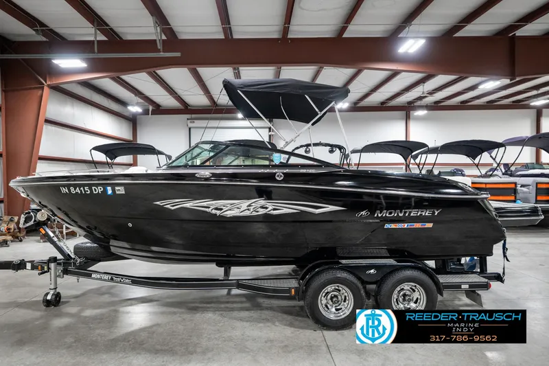 Slide: The Image of 2013 Monterey 232 SS boat in showroom, black exterior, on trailer, with canopy. - 11