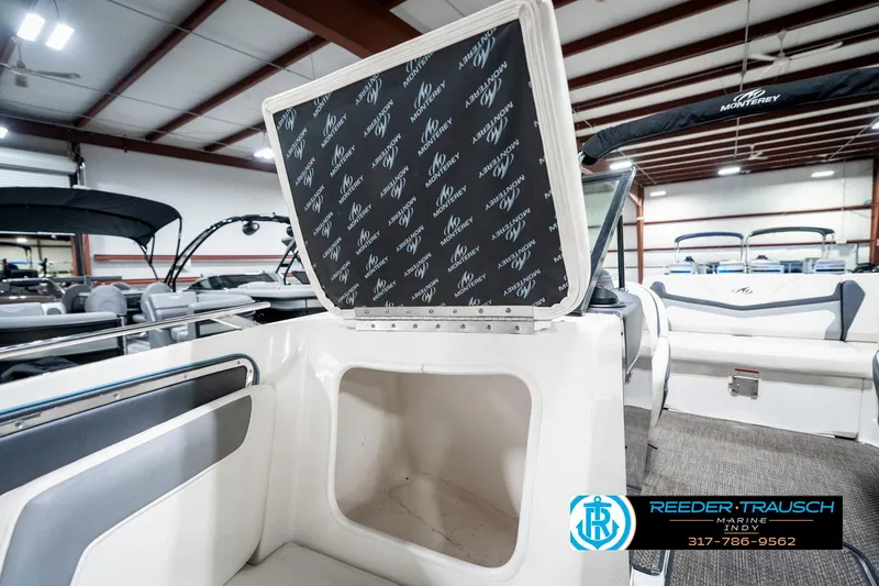 Slide: The Image of 2013 Monterey 232 SS boat storage compartment open in showroom, showcasing interior space. - 26