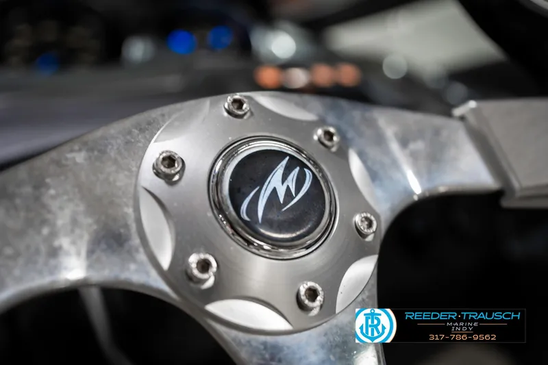 Slide: The Image of Steering wheel of a 2013 Monterey 232 SS boat, featuring a sleek metallic design. - 38