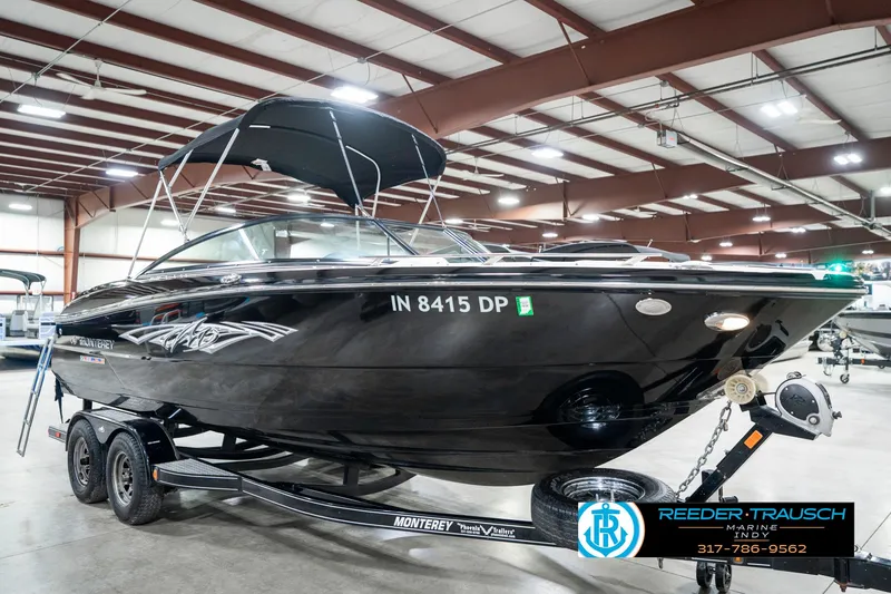 Slide: The Image of 2013 Monterey 232 SS boat in showroom, black exterior, on trailer, with canopy. - 6